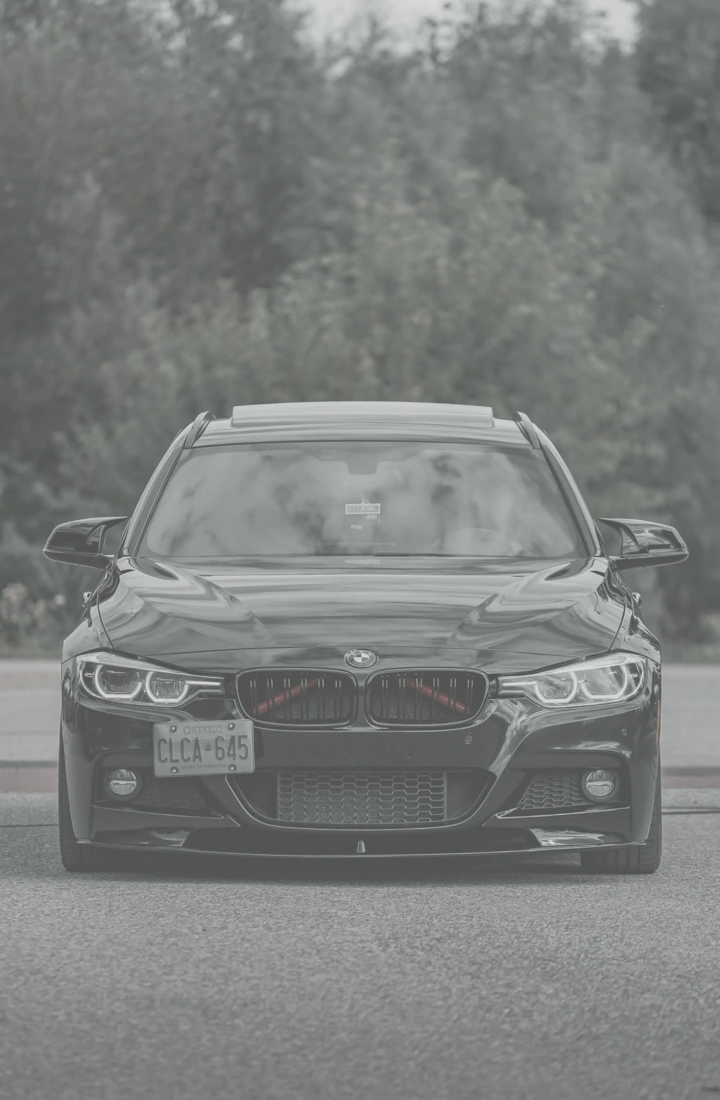 Same black sedan before detailing, dull hazy oxidized paint