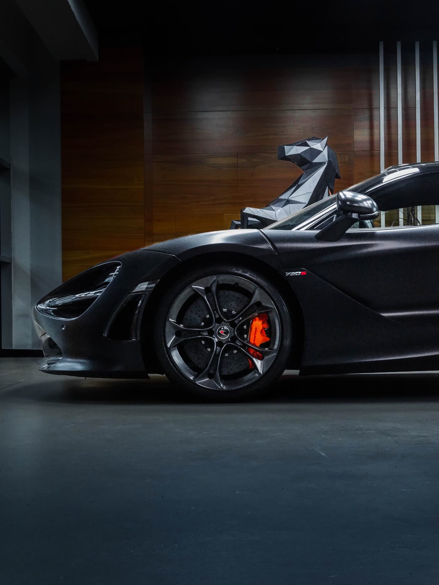 Black supercar front wheel and carbon panel, freshly detailed