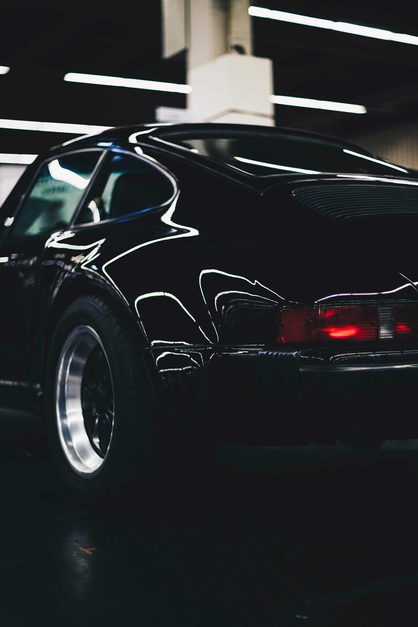 Classic black sports car rear quarter with sharp light reflections