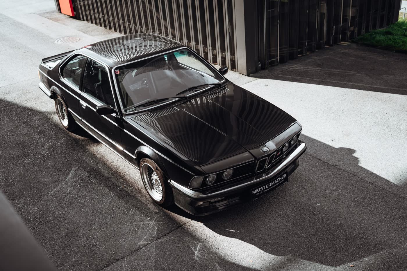 Vintage black coupe with deep glossy paint in sunlight